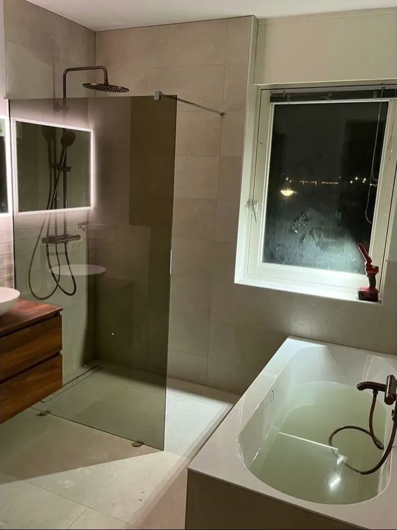 Badkamer met ligbad, inloopdouche en houten badmeubel